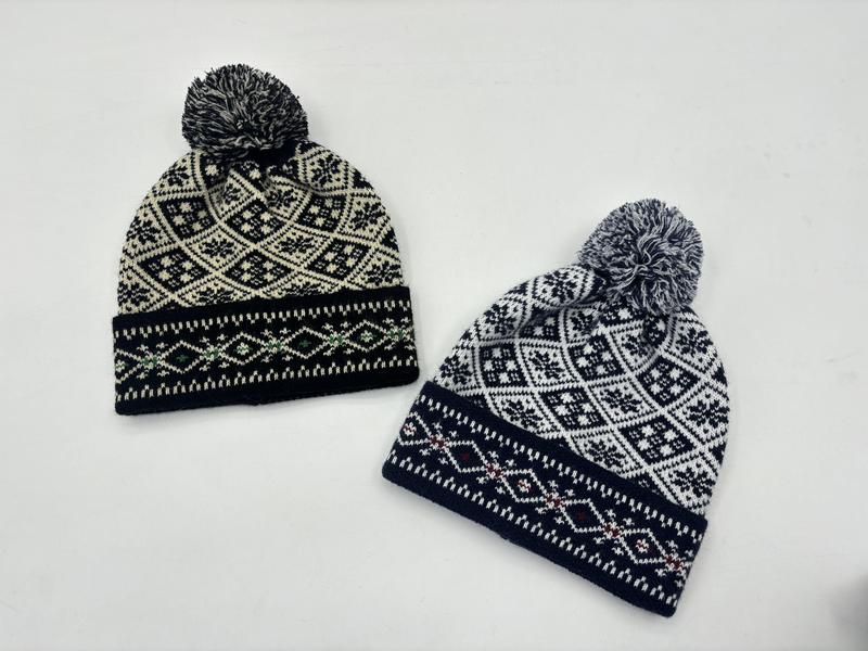 To strikkeluer med pompom i svart/krem og marineblå/hvit med nordisk snøfnuggmønster