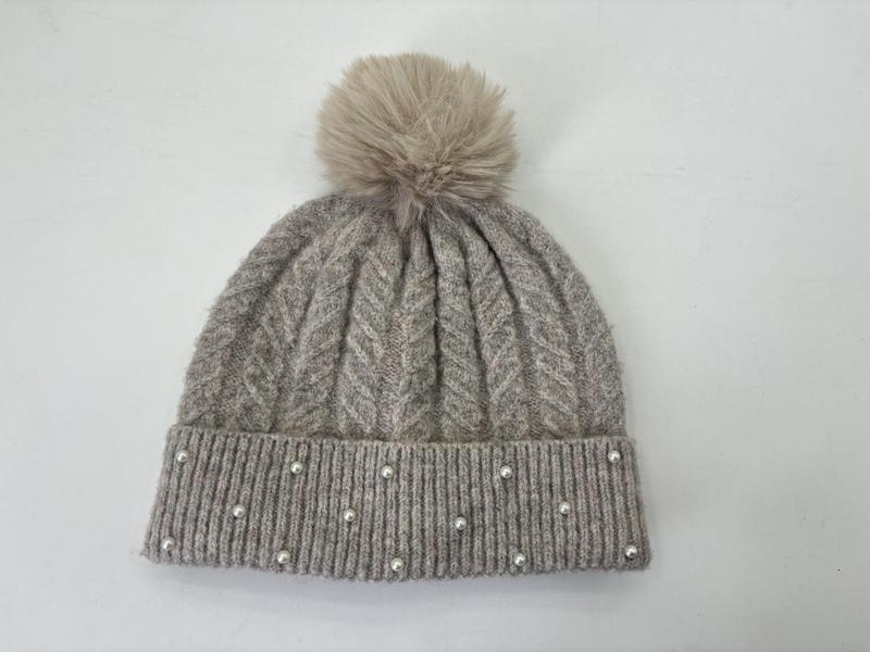 Grå strikket lue med kunstig pels-pom pom og perledekor langs kanten.