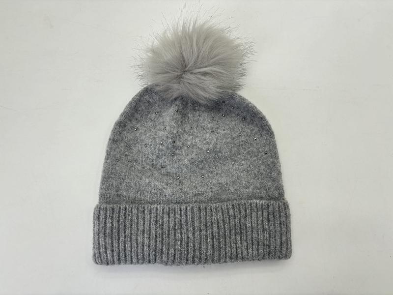 Grå strikket vinterlue med kunstig pelspom-pom på toppen og rhinstein-detaljer på ribbestrikket bremme.