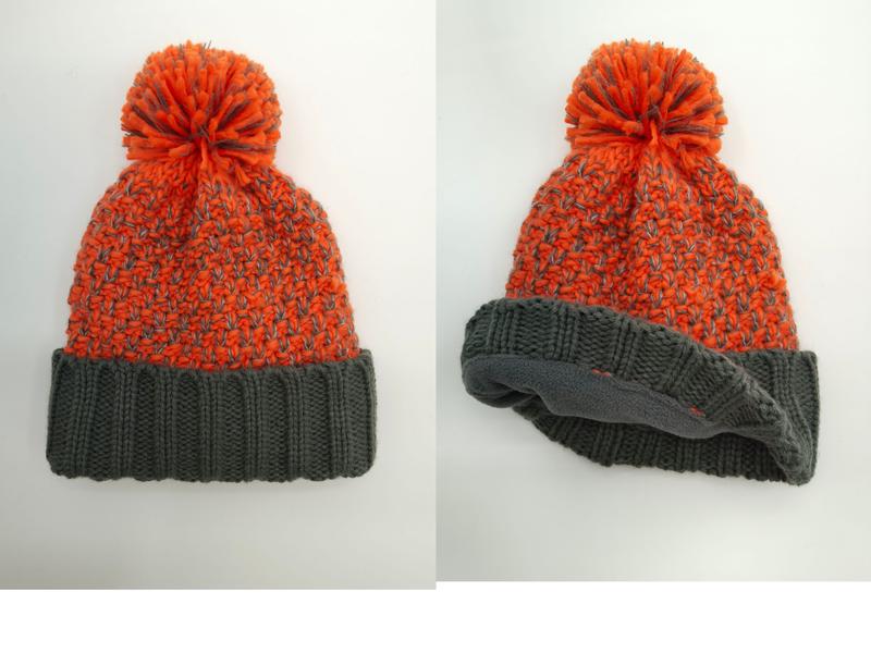 Oransje og grå grovstrikket lue med stor pompom