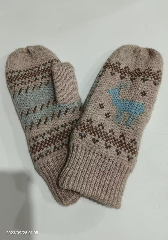 Beige strikkede ullvotter med blått reinsdyrmotiv og nordisk mønster – grossist tilgjengelig.