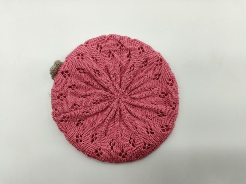 Rosa strikket beret med blomstermønster av blondehull og liten beige pom-pom