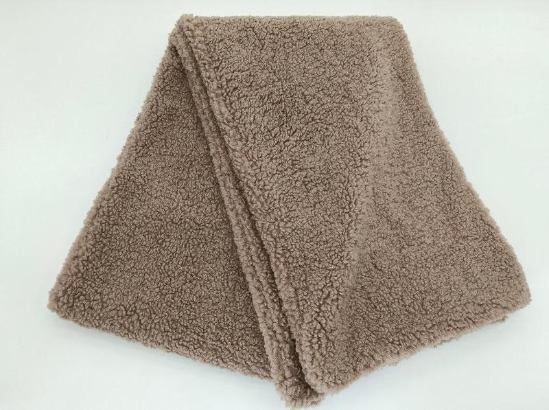 Myk og varm pledd i taupe med krøllete sherpa-fleece tekstur
