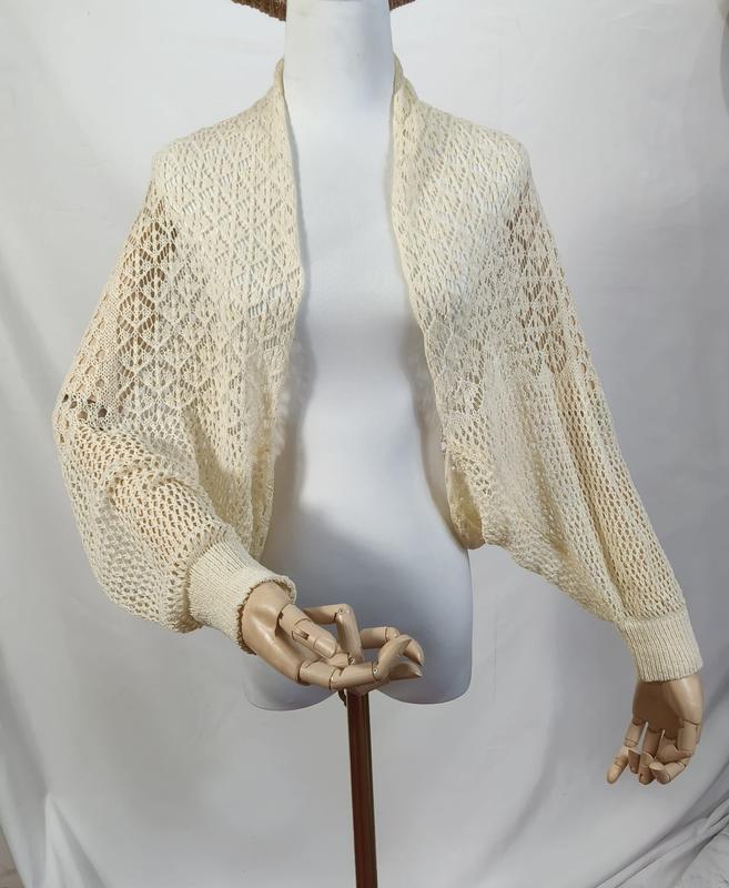Kremfarget åpen strikket crochet bolero med vide ballongErmer i biskopstil.