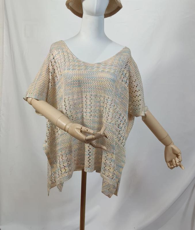 Beige boho poncho topp i løs passform med åpen strikk og heklede detaljer i flere farger.
