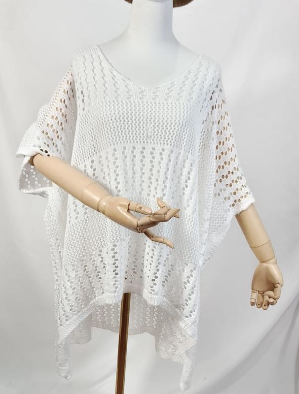 Hvit strandponcho i oversized åpen strikk med V-hals og heklemønster.