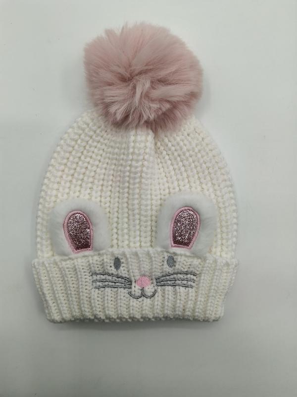 Hvit grovstrikket lue med kaninører og rosa kunstpels-pompom.