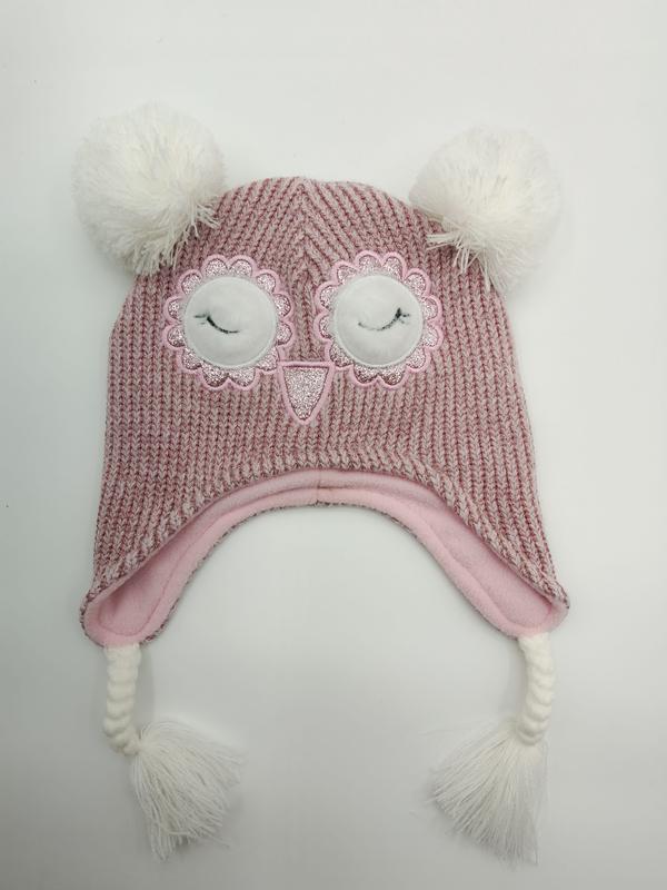 Rosa strikket uglebeanie for barn med pompomer og ørelapper.