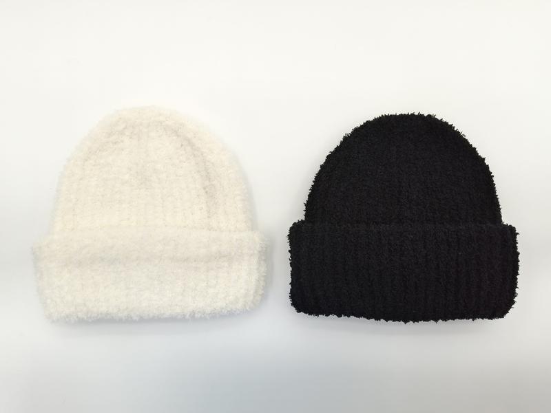 «Kremfarget og sort strikket lue med ribb og fluffy detaljer