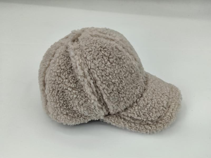 «Beige baseball cap i myk sherpa fleece med strukturert skygge og synlige sømsdetaljer.»
