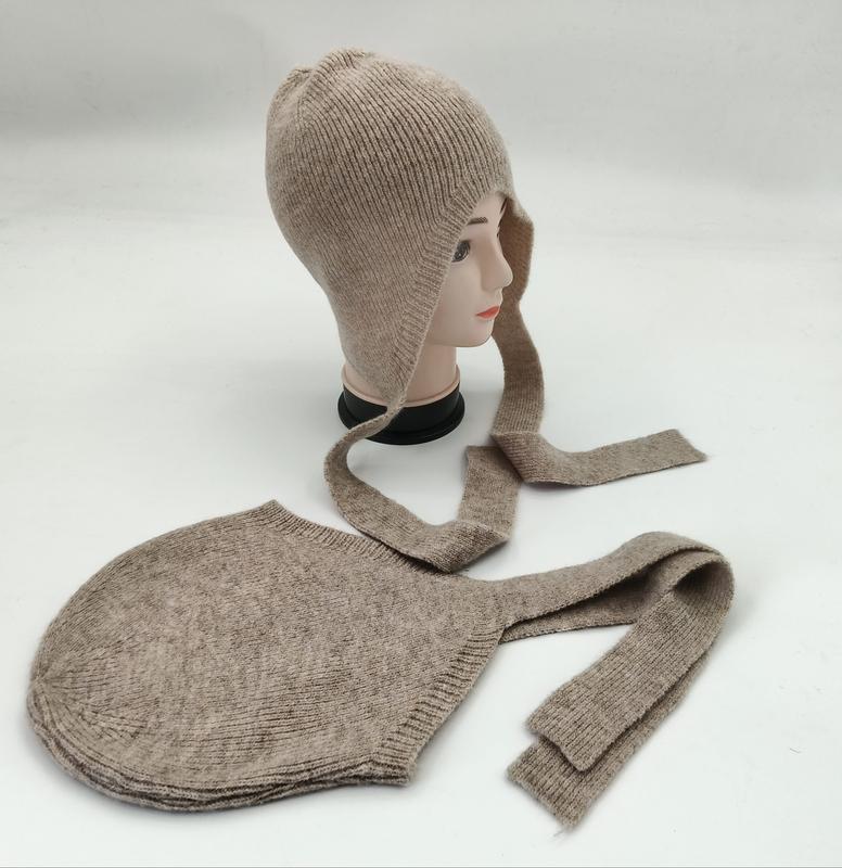 Beige ribbestrikket lue med lange bindebånd og øreflapper