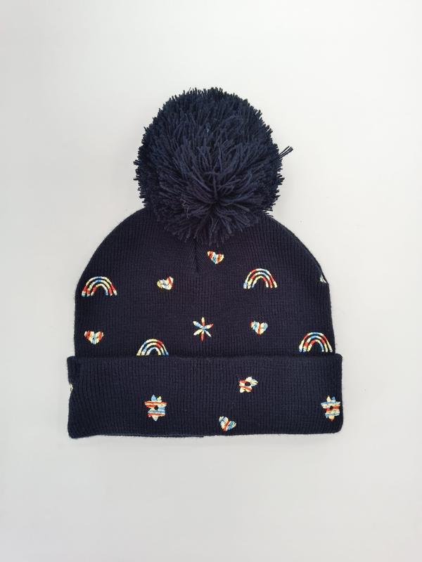 Marineblå strikket lue med stor pompom og fargerike broderte regnbuer