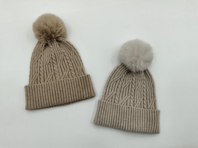 To strikkeluer med flettmønster og kunstpels-pom pom i taupe og lysegrå