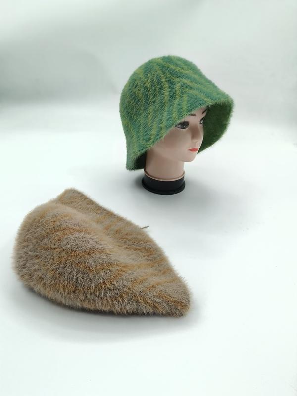 Grønn stripet fluffy strikkebøttehatt på mannequinhode med matchende beige flat caps på hvit bakgrunn.