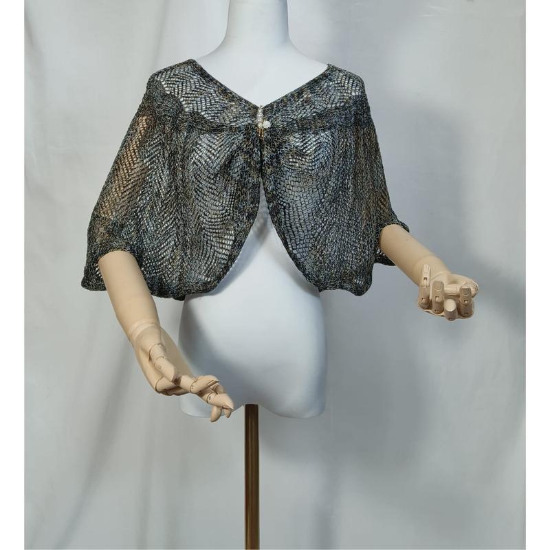 Blågrå metallic blondestrikket capelet shrug på hvit mannequin
