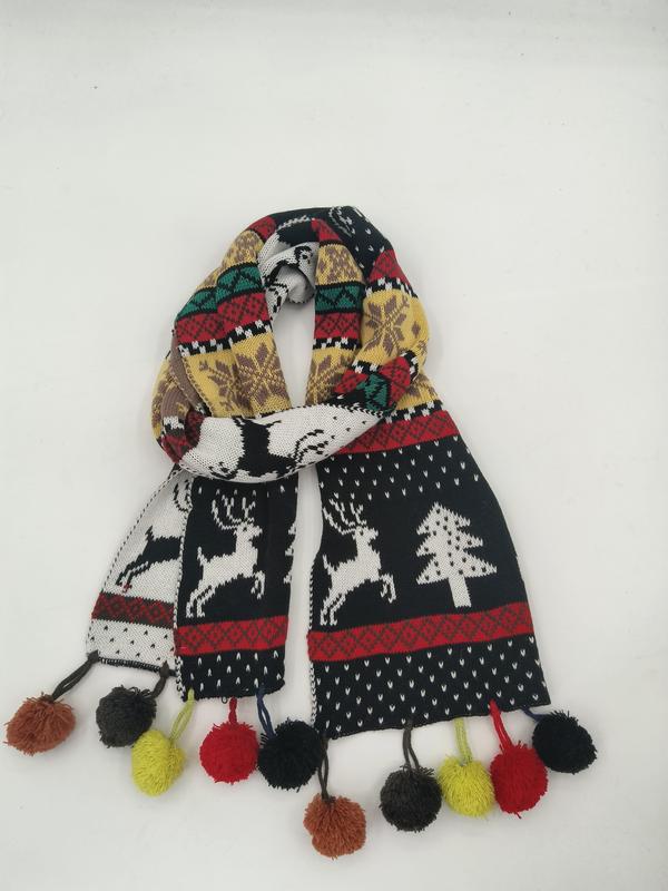 Fargerik strikket juleskjerf med reinsdyr- og juletremønster i Fair Isle-stil og pompomfrynser i flere farger.