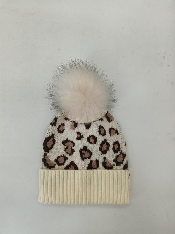 Kremfarget strikket lue med brun leopardmønster og hvit kunstpels-pom-pom på toppen