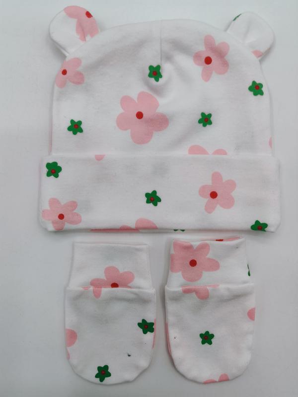 `Hvit bomullslue med bjørnører og matchende votter med rosa og grønt blomstermønster til baby.`
