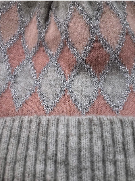 Nærbilde av strikket lue med rosa og grå argyle-diamantmønster