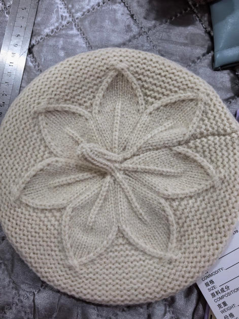 Kremfarget strikket beret med hevet blomsterblad-kabelmønster i kronen – grossist tilgjengelig.