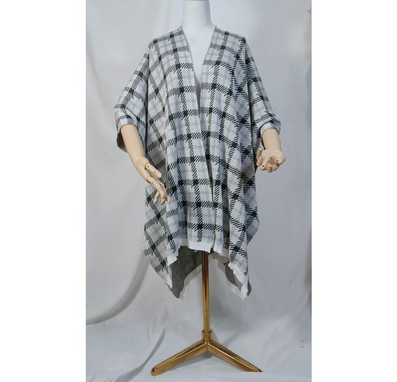 Svart-hvit rutete strikket poncho med åpen front og asymmetrisk