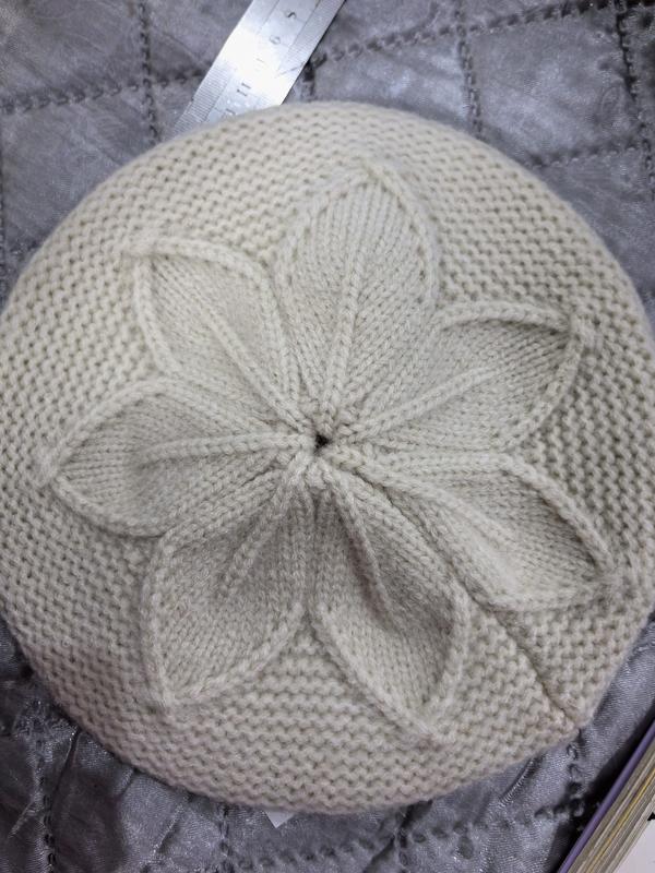 «Kremfarget strikket beret ovenfra med hevet blomstermønster i krone – grossistleverandør av luer»