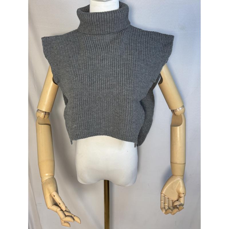 Grå ribbstrikket cropet turtleneck ermeløs sweatervest på mannequin med leddede trearms.