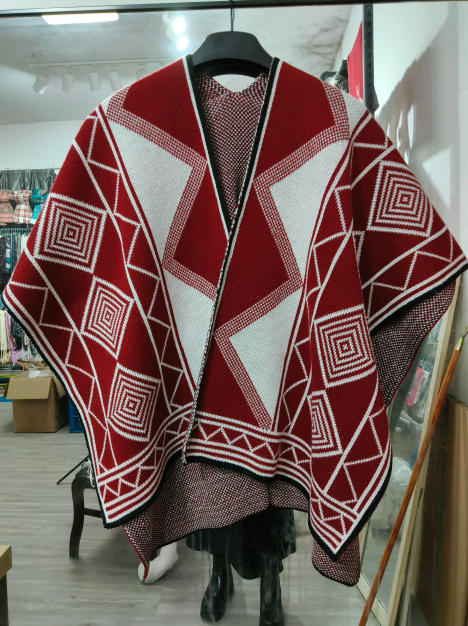 Rød og hvit strikket poncho med geometriske ruter- og diamantmønstre