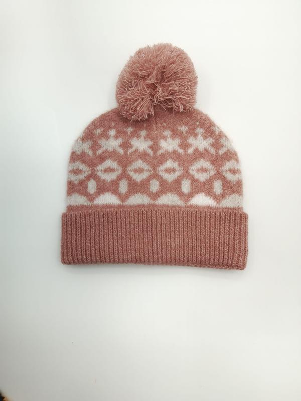 Rosa strikket lue med hvit snøfnuggmønster og pompom.