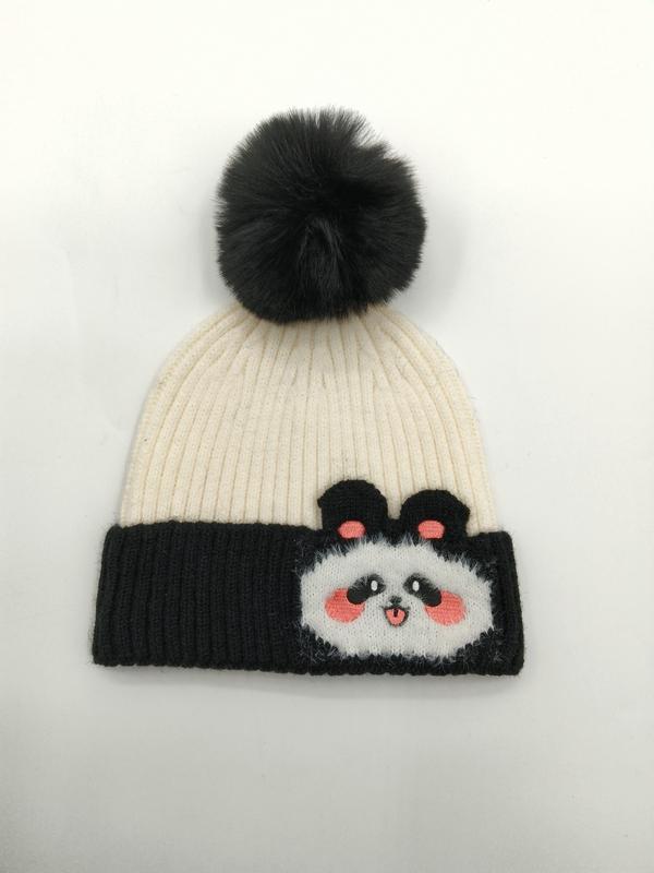 Kremfarget og svart ribbe-strikket lue med søt pandamotiv og mørk kunstpels-pompom på toppen.