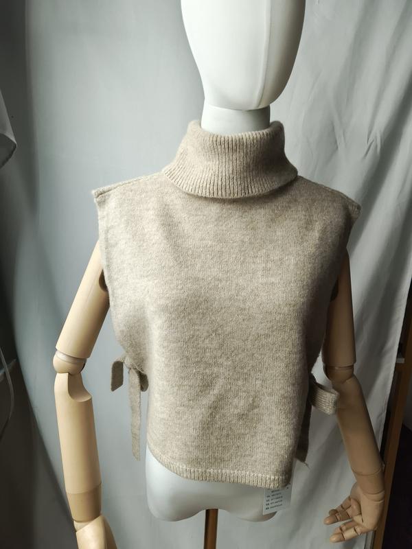 Beige ermeløs strikkevest med rullekrage og sideknytning