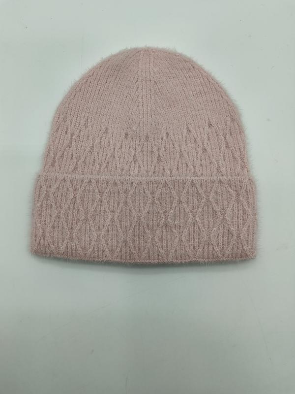 Blush rosa fluffy kabelstrikket lue med diamantmønster og brettet kant på lys bakgrunn.