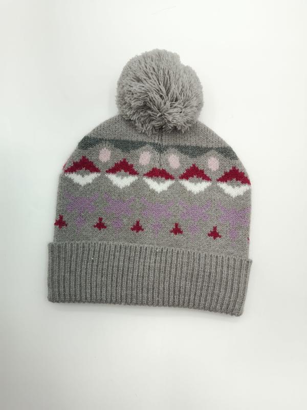 Grå strikket lue med pompom og Fair Isle-mønster i rødt, hvitt, rosa og lilla på hvit bakgrunn.
