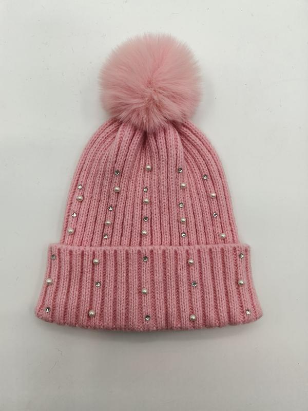 Rosa strikket lue med falsk pelspompon, perler og rhinestener.