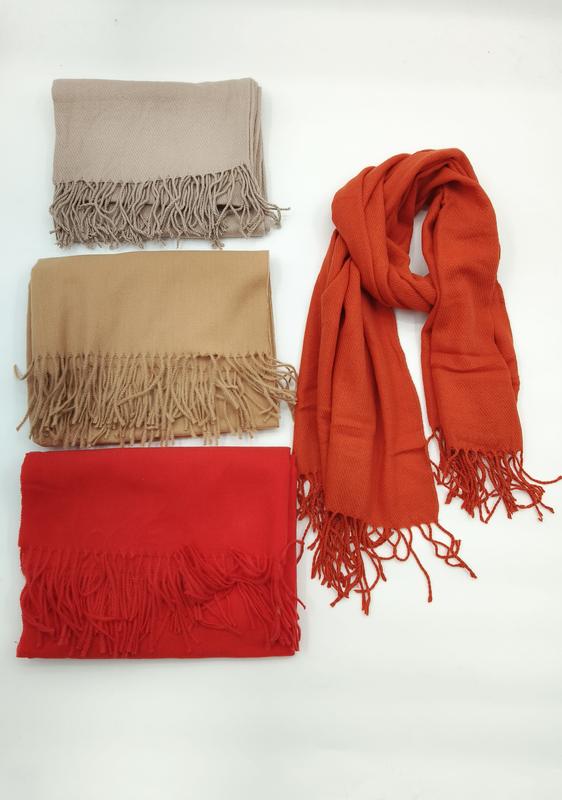 Fire pashmina-skjerf med frynser i beige, kamel, rød og brent oransje – ett drapert, tre brettet.